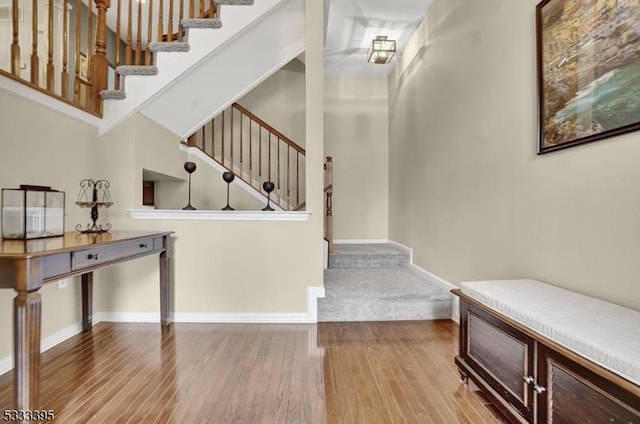 stairway featuring hardwood / wood-style flooring and a towering ceiling