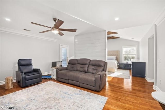 living room featuring hardwood / wood-style flooring, ceiling fan, lofted ceiling, and ornamental molding