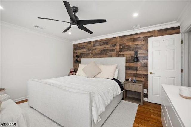 bedroom with hardwood / wood-style flooring, ornamental molding, and ceiling fan