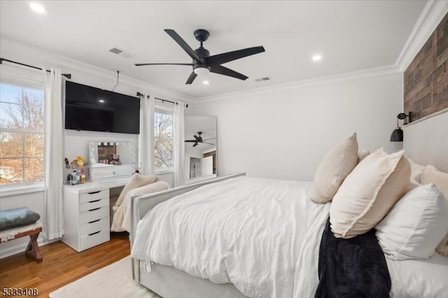 bedroom with wood-type flooring, ceiling fan, and crown molding