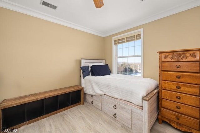 bedroom featuring ornamental molding, light hardwood / wood-style floors, and ceiling fan