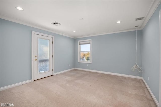 spare room featuring ornamental molding and light colored carpet