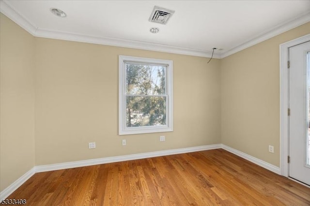 empty room featuring ornamental molding and wood-type flooring