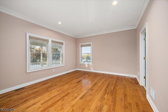 empty room featuring crown molding and light hardwood / wood-style flooring