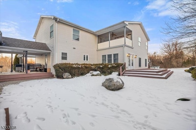 snow covered rear of property featuring ceiling fan