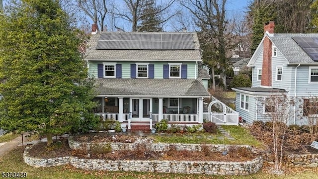 view of front of property with covered porch and solar panels