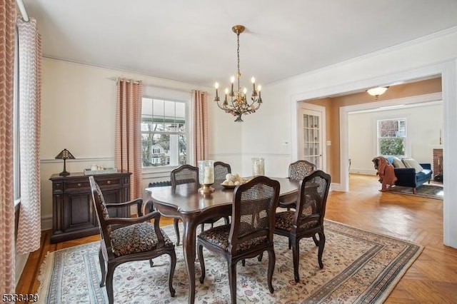 dining room featuring light parquet flooring, a healthy amount of sunlight, and ornamental molding