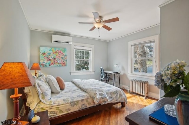 bedroom with crown molding, radiator heating unit, hardwood / wood-style floors, and an AC wall unit