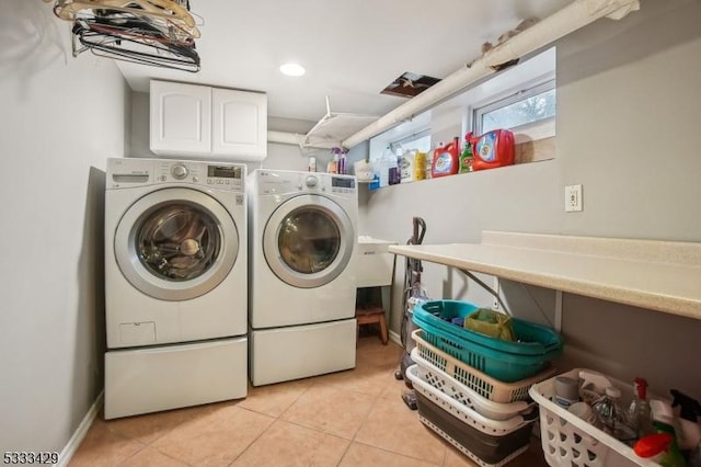 clothes washing area with light tile patterned flooring and washer and clothes dryer