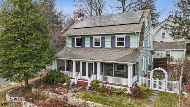 view of front of property with covered porch and solar panels