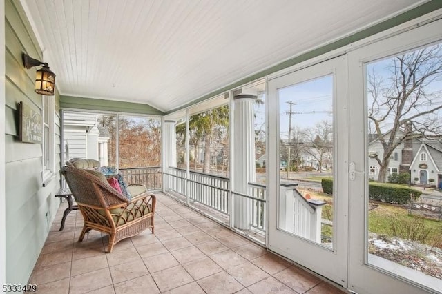 sunroom / solarium with lofted ceiling, a healthy amount of sunlight, and wooden ceiling