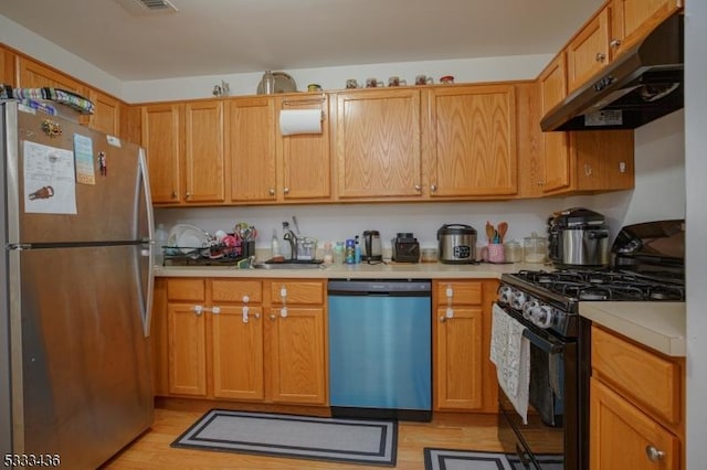 kitchen with stainless steel appliances and light hardwood / wood-style flooring