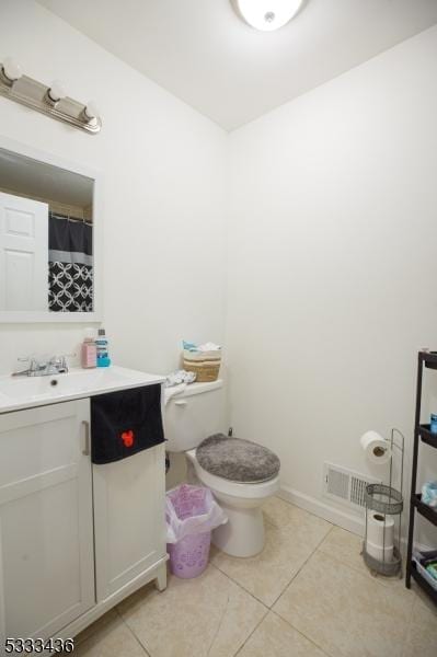 bathroom featuring toilet, tile patterned floors, and vanity