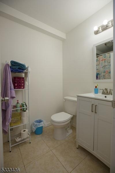 bathroom featuring toilet, tile patterned floors, and vanity