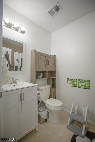 bathroom featuring tile patterned floors, toilet, and vanity