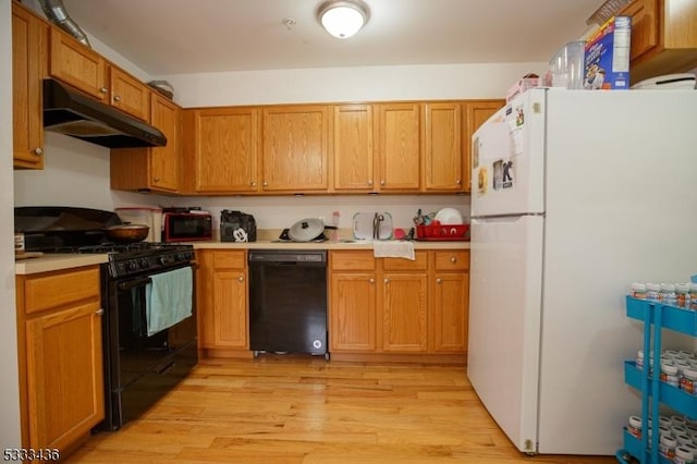 kitchen with light hardwood / wood-style flooring and black appliances