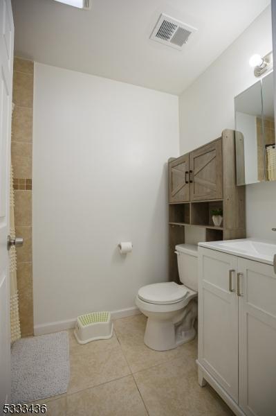 bathroom featuring toilet, vanity, and tile patterned floors