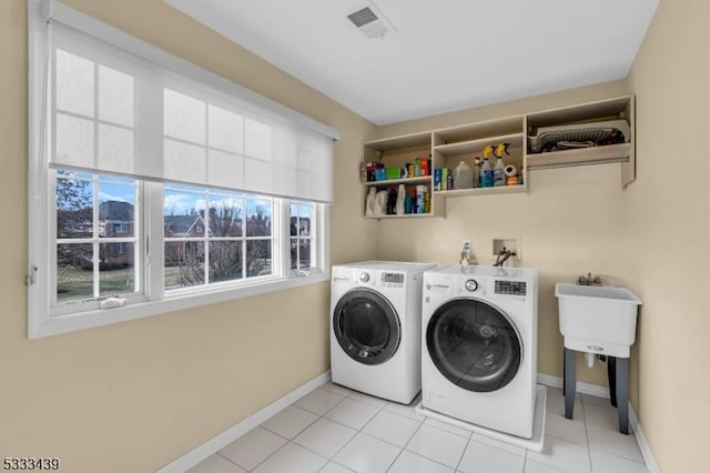 washroom featuring washing machine and dryer and light tile patterned flooring