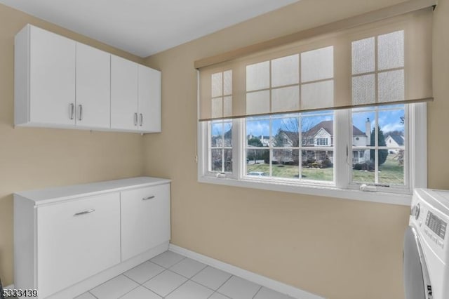 washroom featuring light tile patterned floors, separate washer and dryer, and cabinets