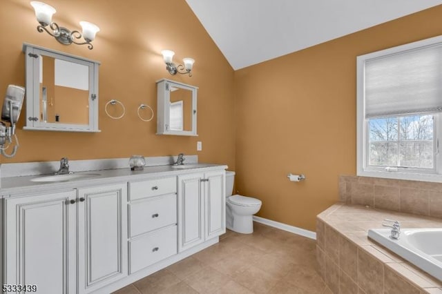 bathroom with tile patterned floors, vanity, toilet, vaulted ceiling, and tiled bath