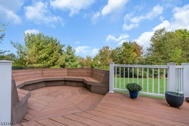 wooden deck featuring a lawn