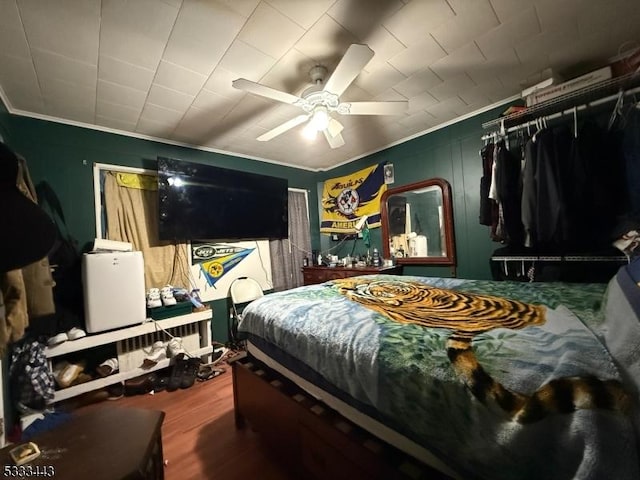 bedroom featuring crown molding, hardwood / wood-style floors, and ceiling fan