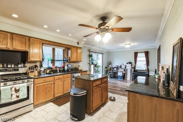 kitchen with dark stone counters, crown molding, stainless steel appliances, and a center island