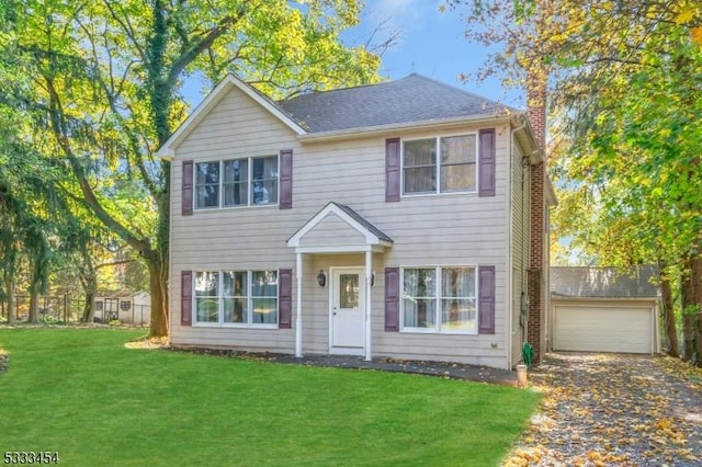 colonial house featuring a front yard and a garage