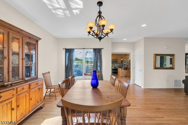 dining room with a chandelier and light hardwood / wood-style flooring