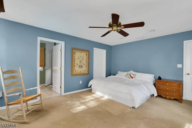 bedroom featuring ceiling fan, ensuite bath, and light carpet