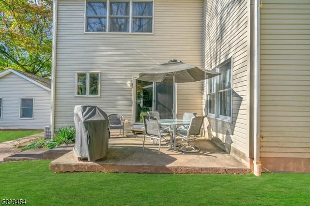 rear view of property featuring a patio area and a lawn