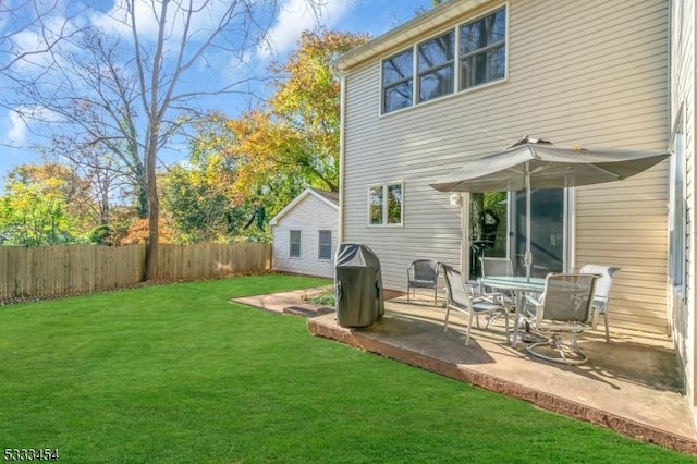 rear view of house featuring a lawn and a patio