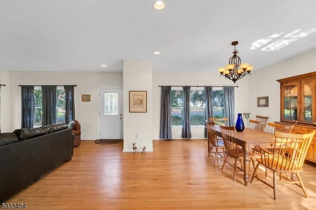 dining area featuring light wood-type flooring and a notable chandelier