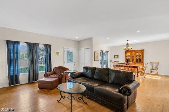 living room featuring light wood-type flooring and a notable chandelier