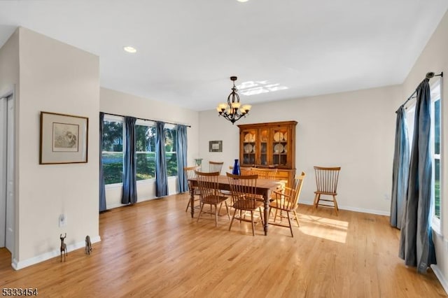 dining room with an inviting chandelier and light hardwood / wood-style flooring