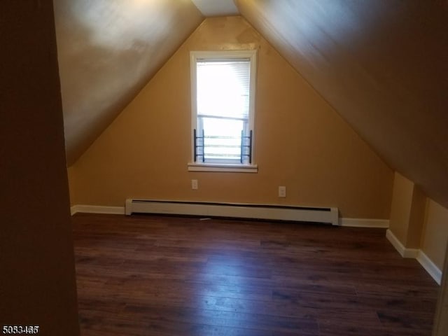 additional living space with a baseboard heating unit, dark wood-type flooring, and lofted ceiling