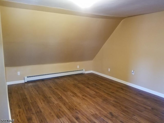 additional living space with a baseboard heating unit, dark hardwood / wood-style floors, and lofted ceiling