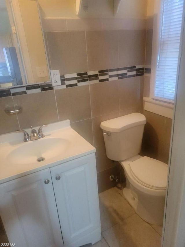 bathroom with tile patterned flooring, vanity, backsplash, tile walls, and toilet