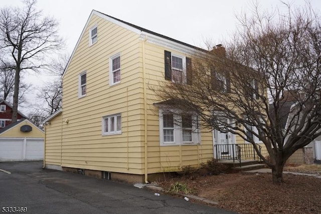 view of side of home featuring a garage and an outdoor structure