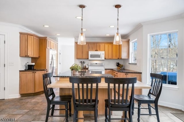 kitchen with ornamental molding, stove, backsplash, and decorative light fixtures