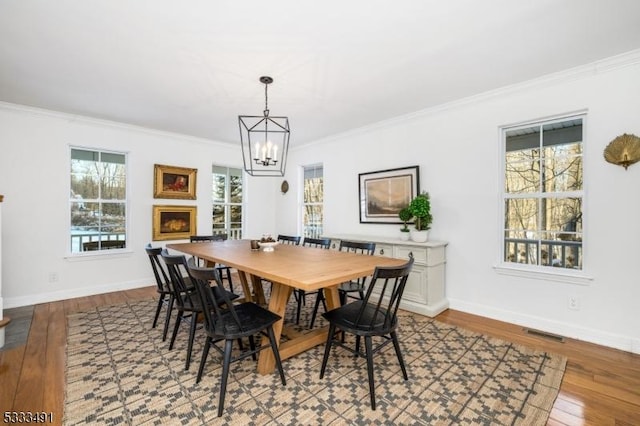 dining area featuring a notable chandelier, crown molding, and light hardwood / wood-style floors