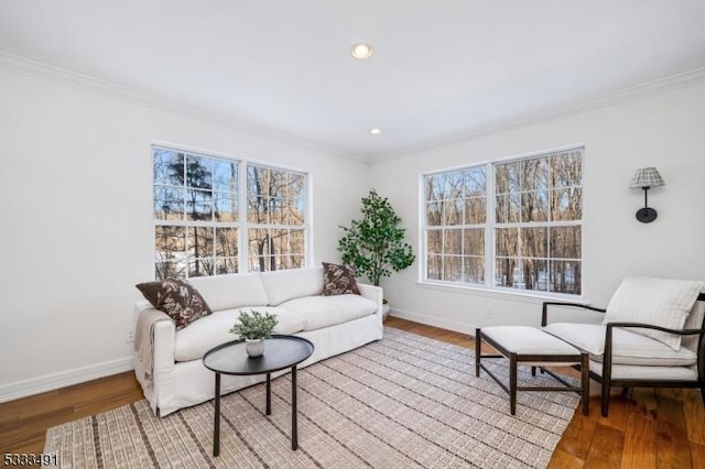 living room with wood-type flooring, a wealth of natural light, and crown molding