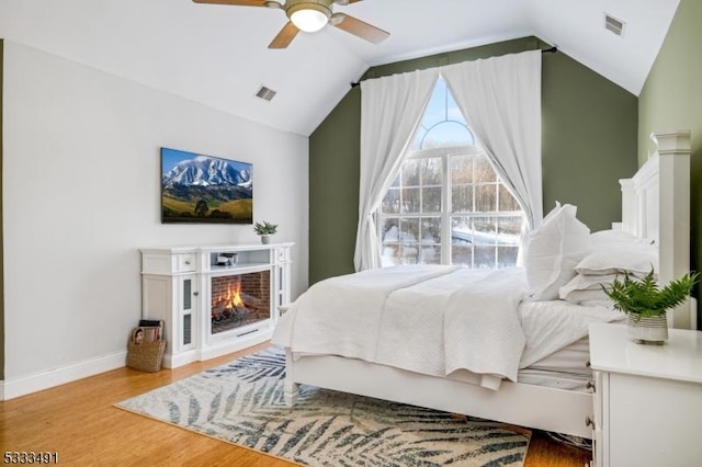 bedroom featuring ceiling fan, lofted ceiling, and light wood-type flooring