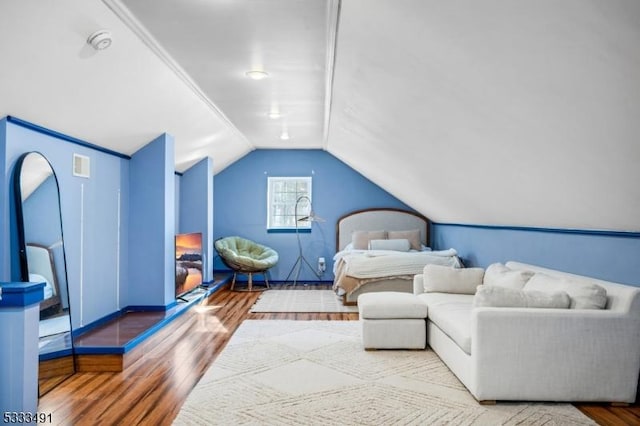 bedroom with hardwood / wood-style flooring and lofted ceiling