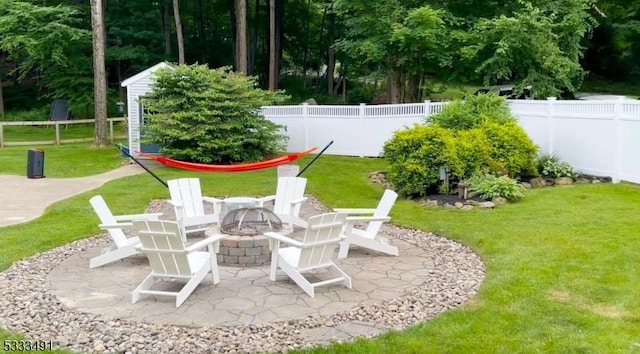 view of yard featuring a patio, an outdoor structure, and a fire pit