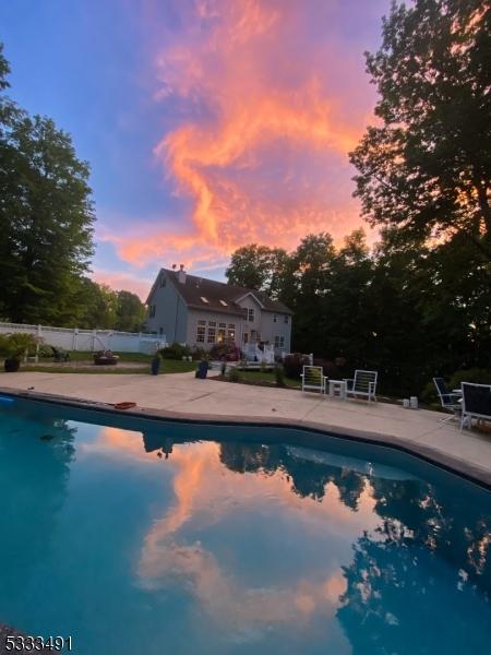 pool at dusk featuring a patio area