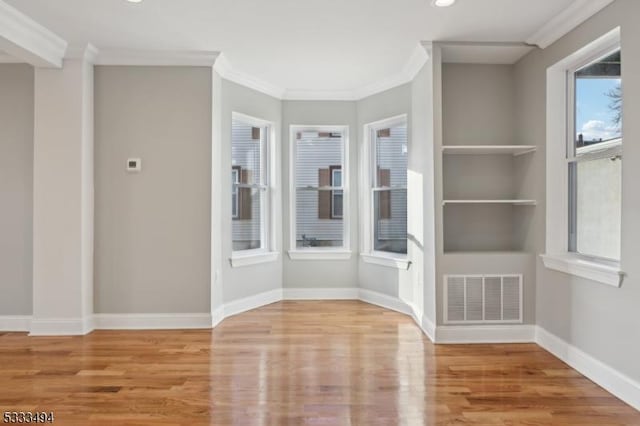 spare room featuring hardwood / wood-style flooring and ornamental molding