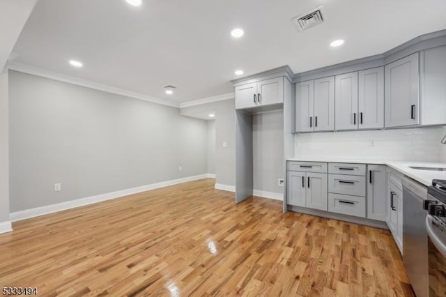 kitchen featuring tasteful backsplash, gray cabinets, light hardwood / wood-style floors, sink, and crown molding