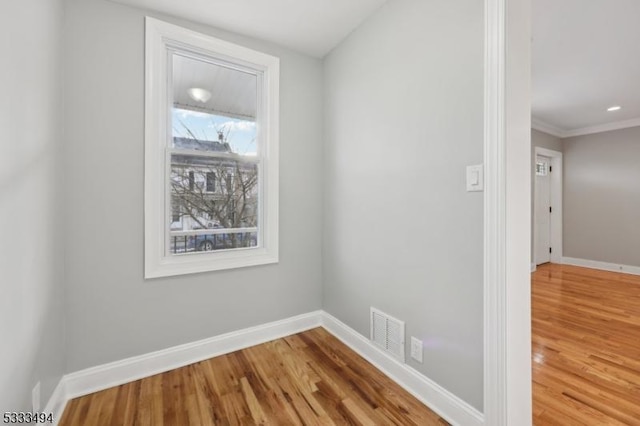 interior space with hardwood / wood-style floors and ornamental molding