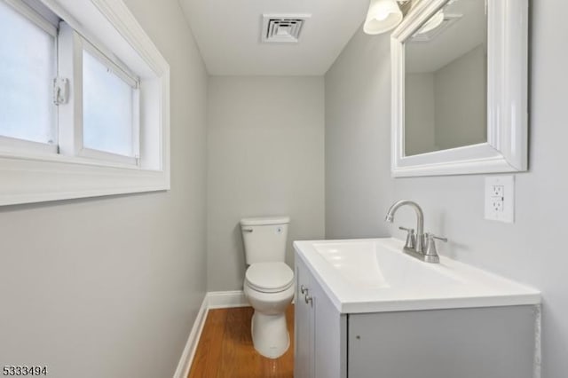 bathroom featuring hardwood / wood-style flooring, toilet, and vanity